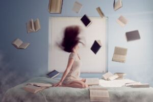 Woman experiencing burnout throwing books in the air